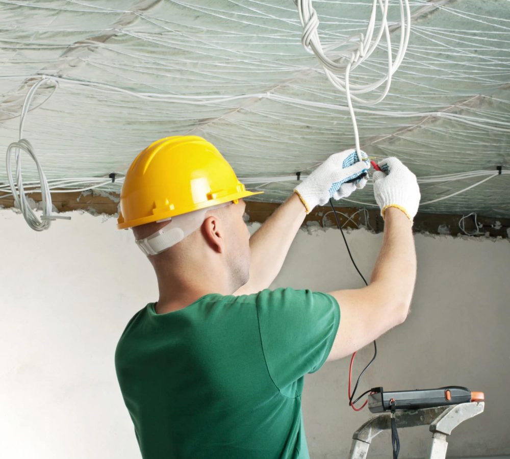 electrician with multimeter checking voltage Electricians Industrial Commercial Lomira, WI